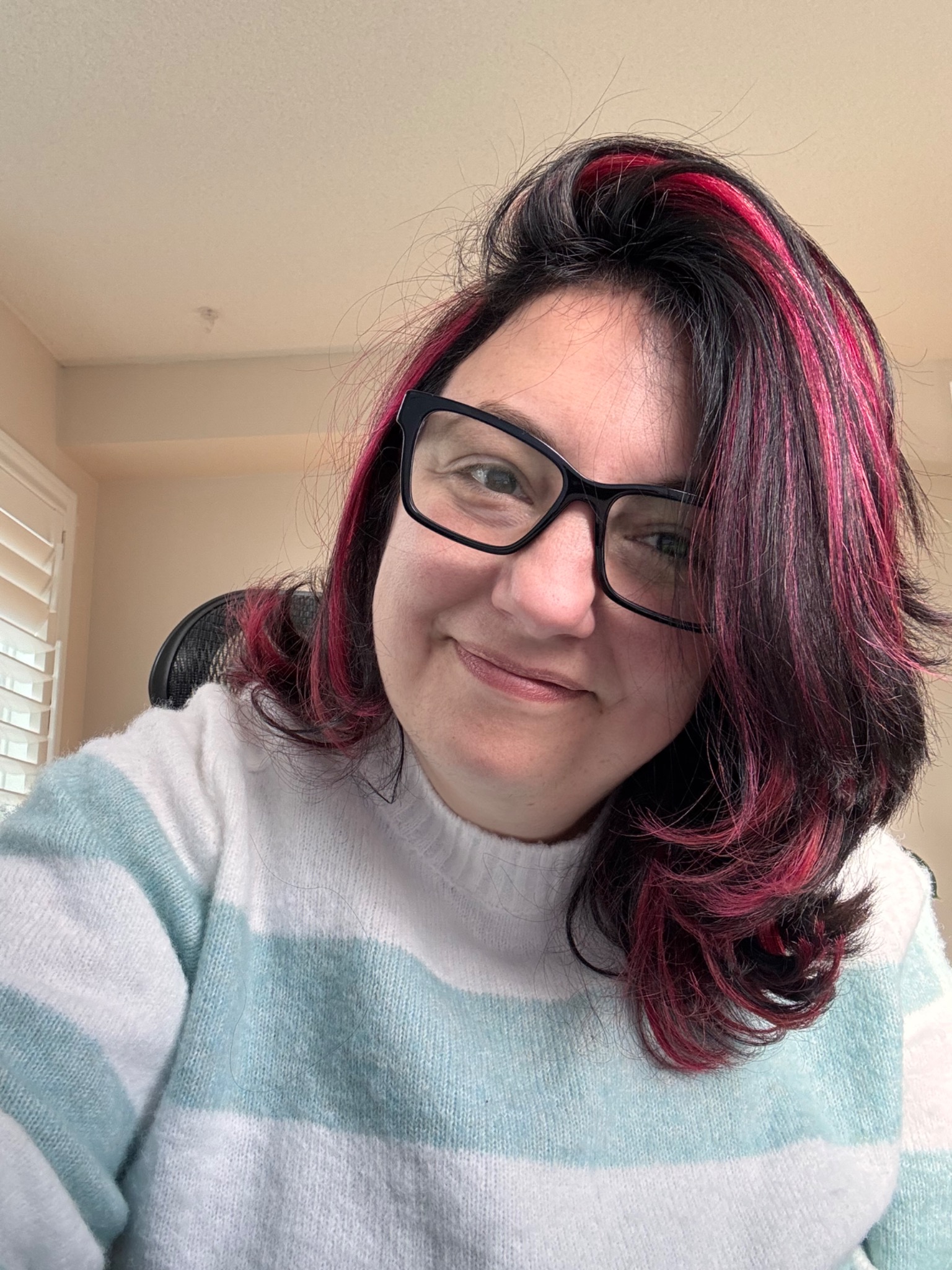 Pauline O’Brien wearing black glasses and a mint and white striped sweater